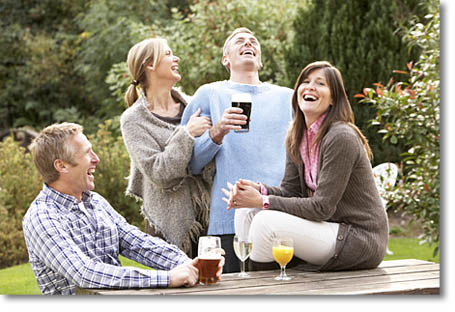 Group Of Friends Outdoors Enjoying Drink In Pub Garden